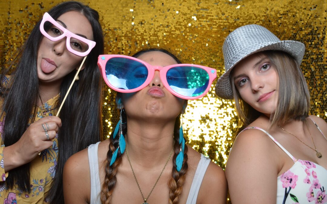 Three women posing for a photo in a photo booth