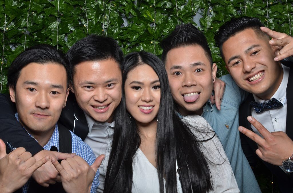 Five people posing together in a photo booth